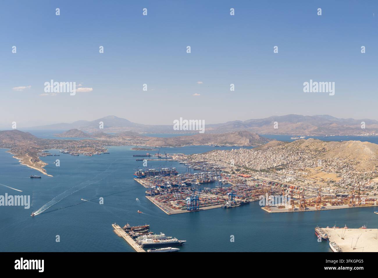 Terminale portuale di Drapetsona affollata da numerose navi portacontainer, gru e container di carico, rappresentando un hub vitale per il commercio e il trasporto globale Foto Stock
