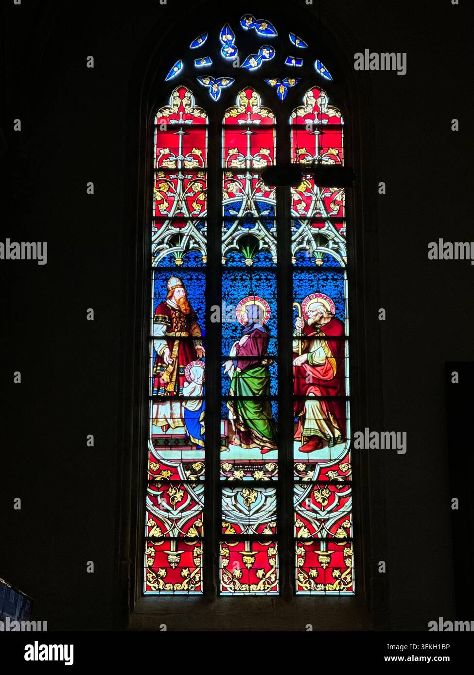 Vetrata colorata con figure religiose in una chiesa. Vetrata gotica ornata all'interno di una cattedrale con pannelli colorati - Immagine stock catturata con smartphone