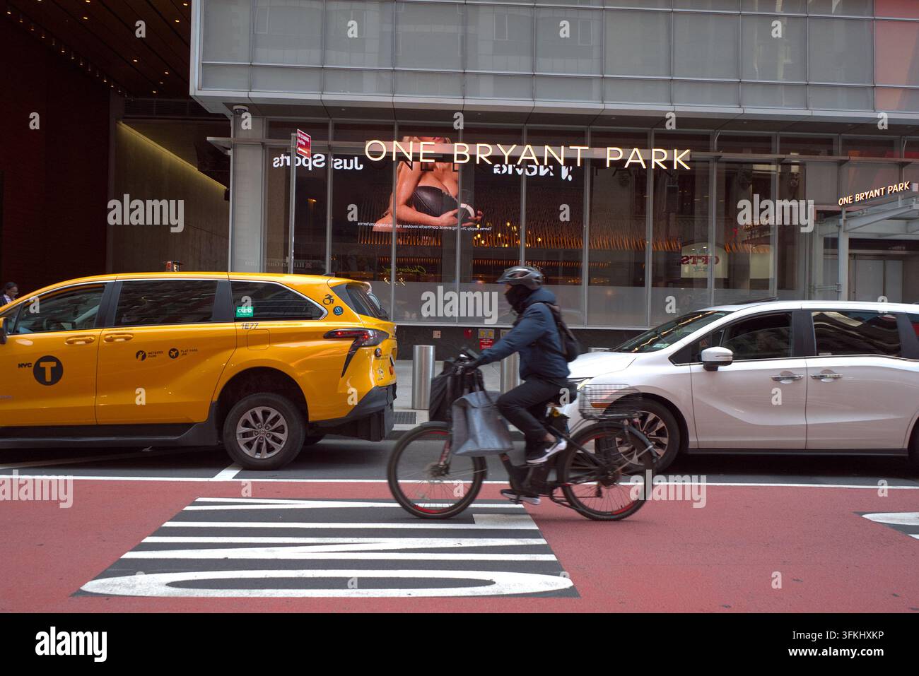 Addetto alle consegne in bicicletta mentre trasporta pacchi per le strade di New York City. Foto Stock