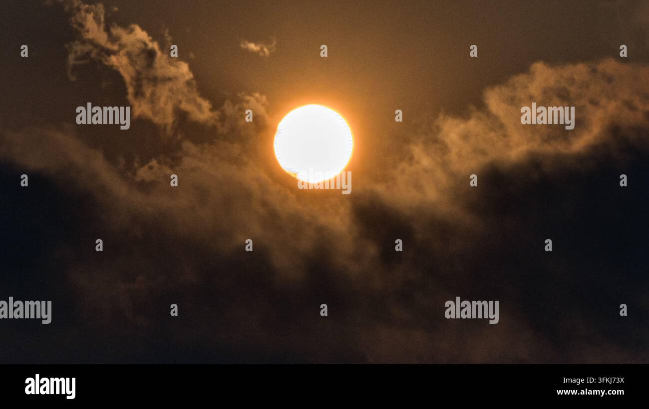 Sole splendente che splende tra le nuvole Foto Stock