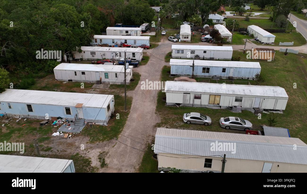 Vecchie case mobili arrugginite per basso reddito nel distretto pericoloso della periferia di Brandon, Florida. Scatto aereo durante l'atterraggio. Area abitativa sporca di una città americana. Foto Stock
