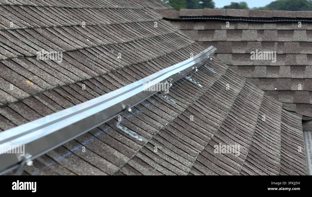 Primo piano di un tetto con binari di montaggio dei pannelli solari installati. Vista aerea di un'installazione solare residenziale su tetto di tegole, College Township, Pennsylva Foto Stock