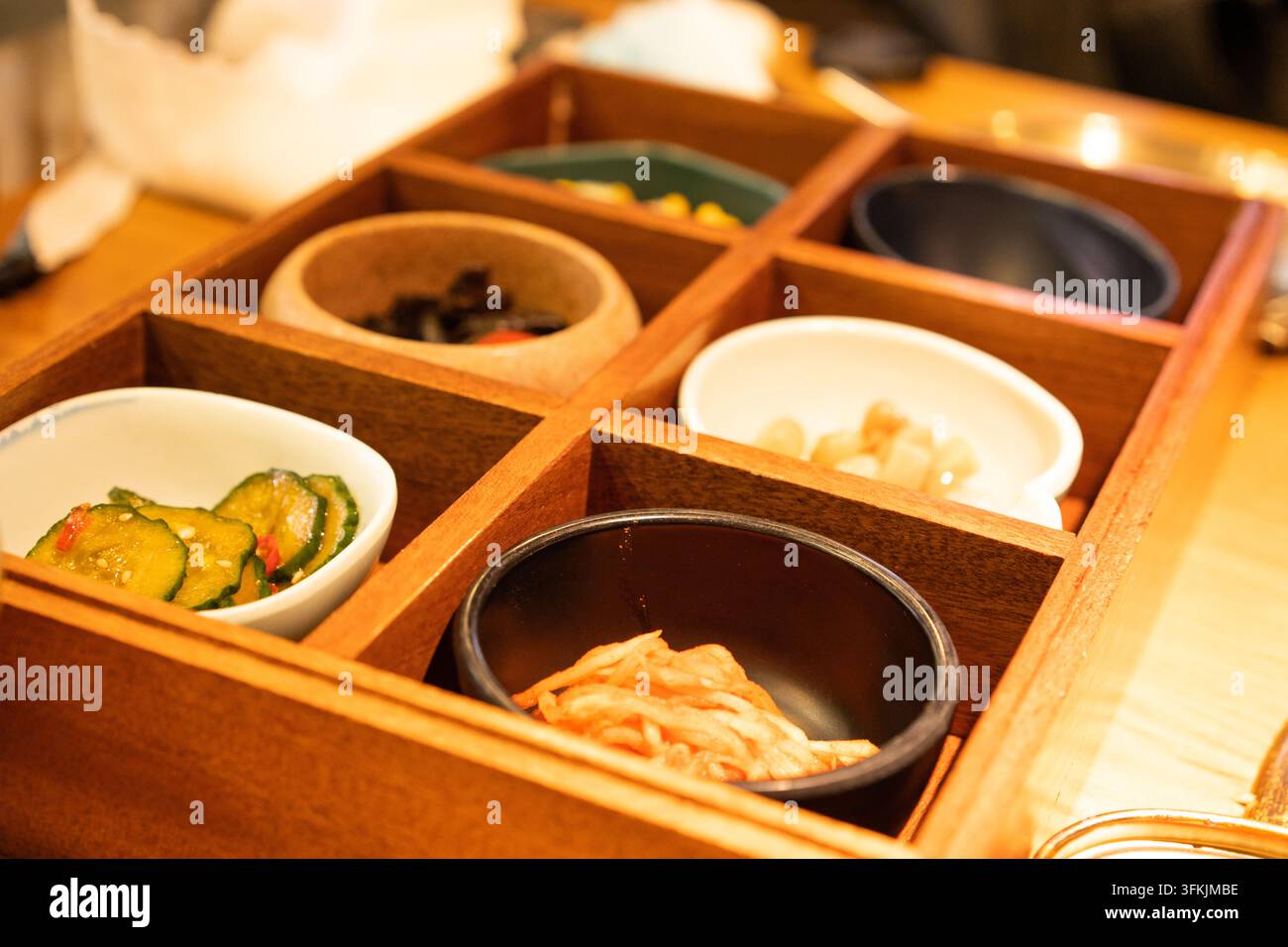 Prima vista di un vassoio banchan in legno con sei scomparti in un ristorante coreano Foto Stock