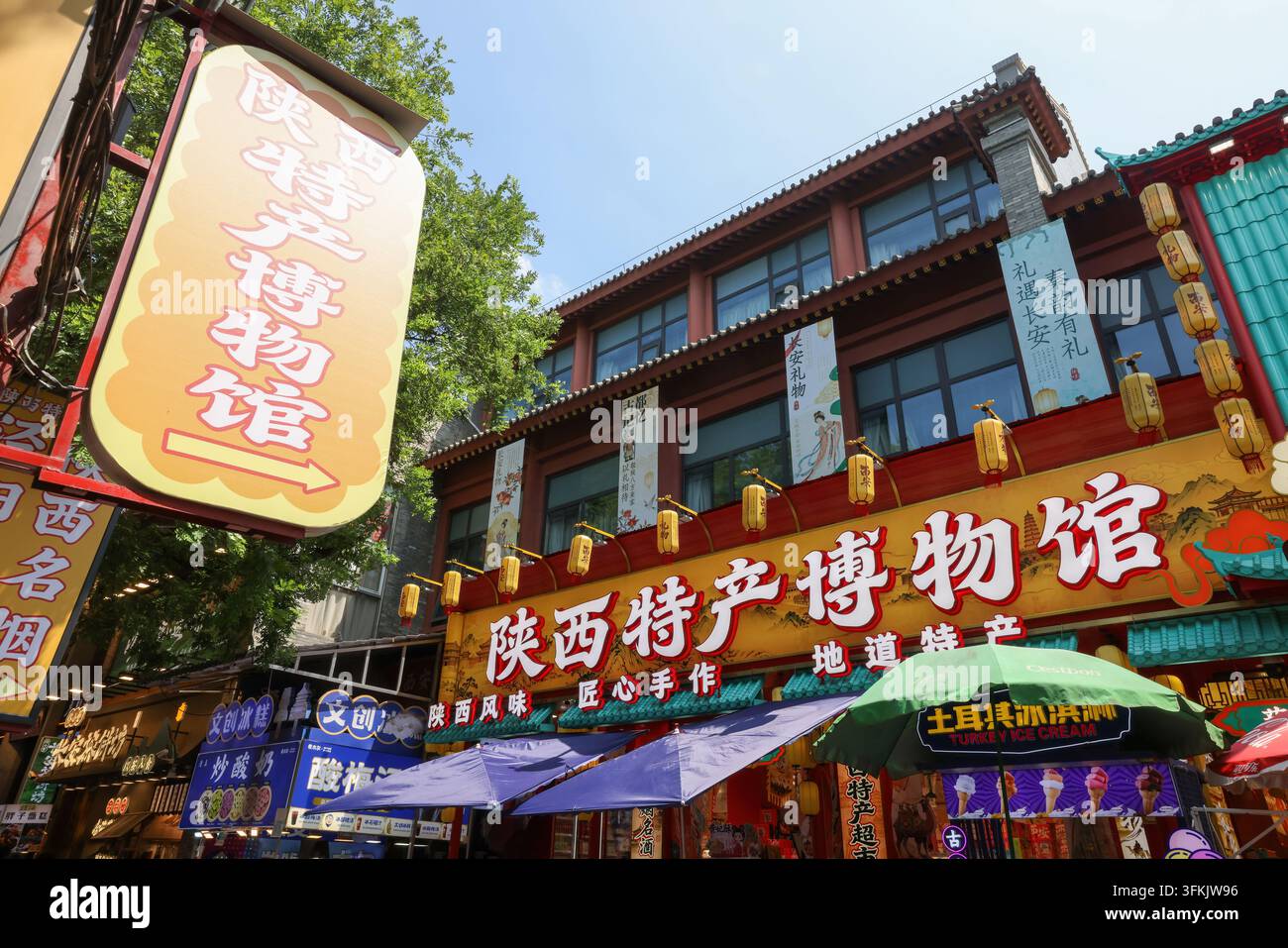 Una zona commerciale colorata nel distretto di Lianhu, Xi'an, Cina. Il negozio a destra vende prodotti specializzati dello Shaanxi Foto Stock