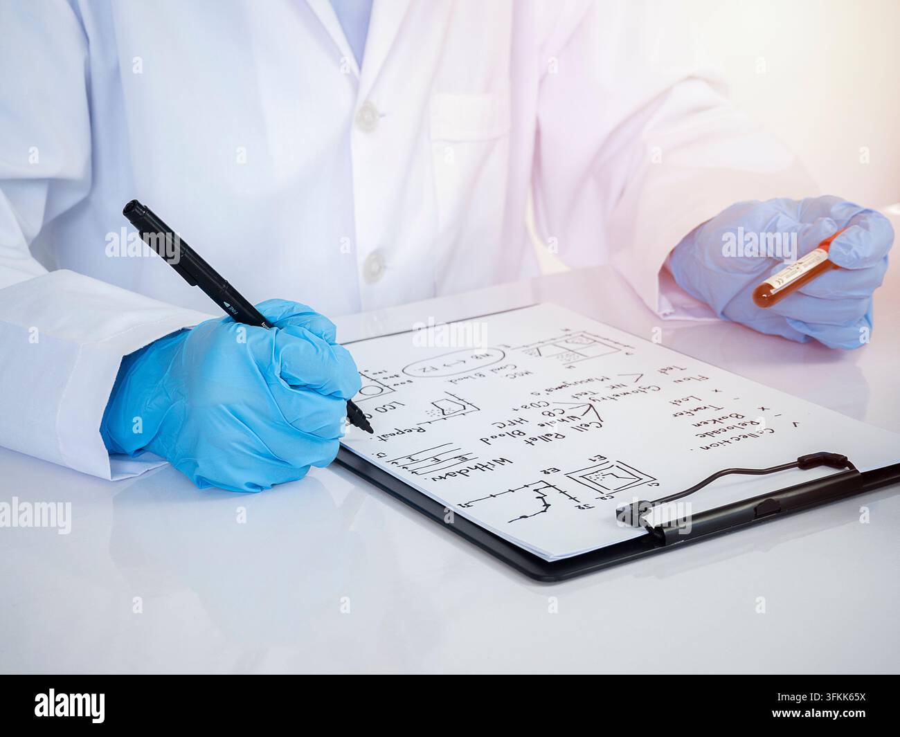 Giovani scienziati con provetta e che fanno ricerche in un laboratorio clinico e prendono appunti. scienza, chimica, tecnologia, biologia e le persone concepiscono Foto Stock
