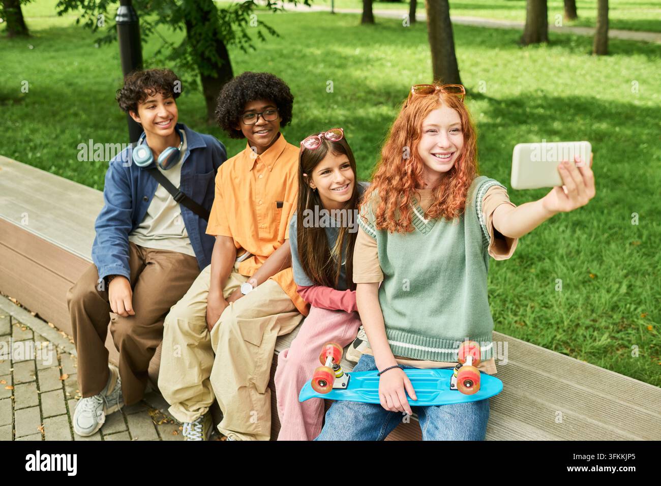Adolescenti multirazziali diversi che scattano un selfie con lo smartphone nel parco Foto Stock