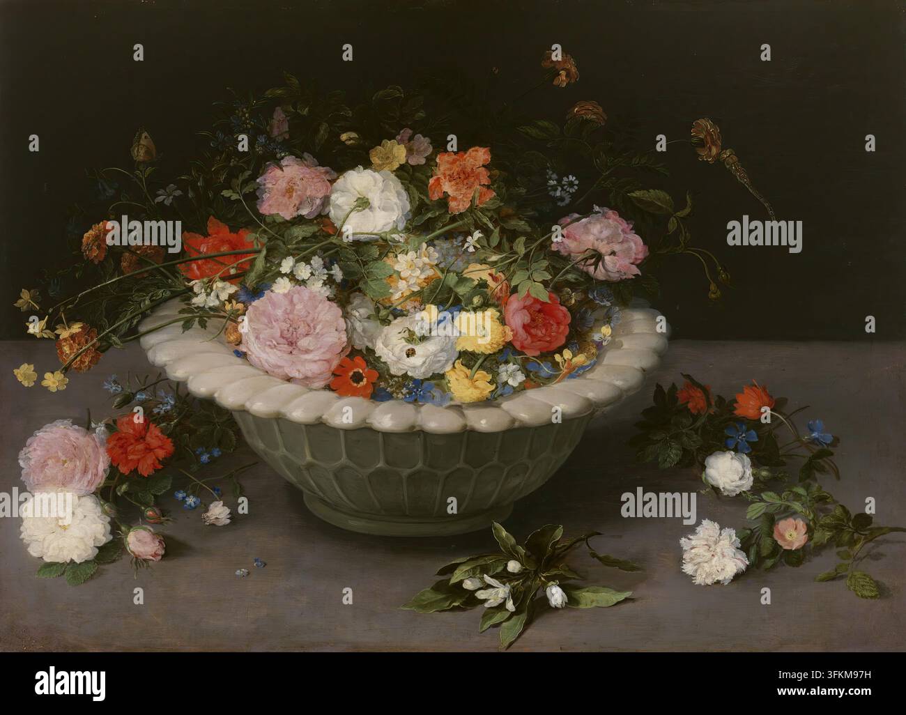 Fiori in una ciotola, 1615. Su un tavolo è posizionata una ciotola di ceramica con un bordo sfrangiato, contenente una moltitudine di fiori di specie diverse e colori vivaci. Tra questi, ci sono garofani, vari tipi di rose, giunchiglie e anemoni, anche se il vaso non riesce a contenerli tutti, alcuni cadono disordinatamente sul tavolo. Un ramoscello di fiore d’arancio si distingue in modo evidente in primo piano. Come rivela la corrispondenza dell’artista, Brueghel cercò di riprodurre fedelmente la varietà e la bellezza dei fiori, per cui viaggiò in luoghi diversi e attese che le varie specie fiorissero. Live anim Foto Stock