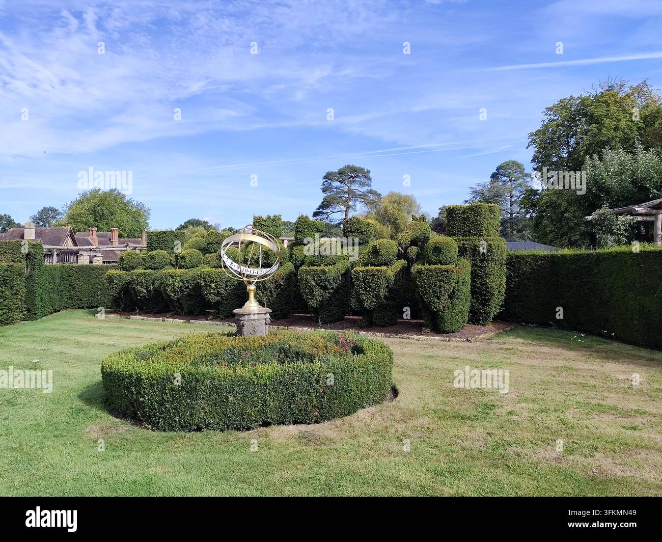 Sfera armillare dorata (circa 1710) e set di scacchi topiario a forma di pezzi di scacchi Tudor piantato da W.W. Astor nel 1905 a Hever Castle, Kent, Regno Unito Foto Stock