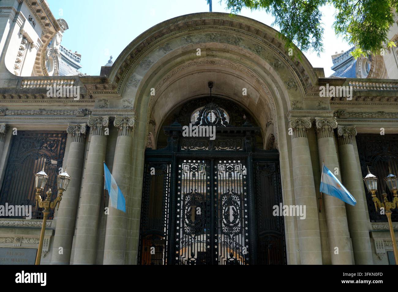 Grandioso ingresso in stile Beaux-Arts del Palacio San Martin a Buenos Aires con cancelli in ferro decorati, colonne in pietra e bandiere argentine. Foto Stock