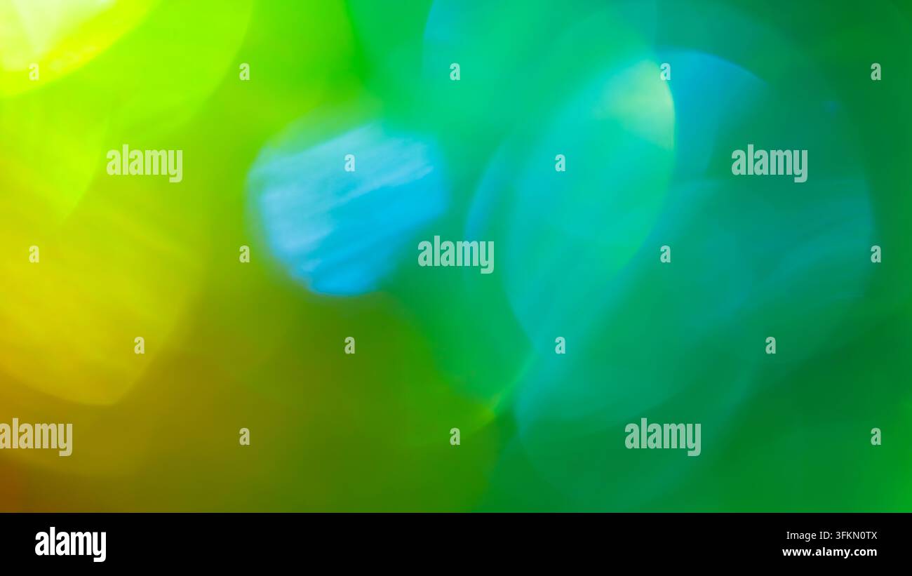 Sfondo sfocato bokeh astratto con morbidi cerchi ciano e verdi e riflessi gialli Foto Stock