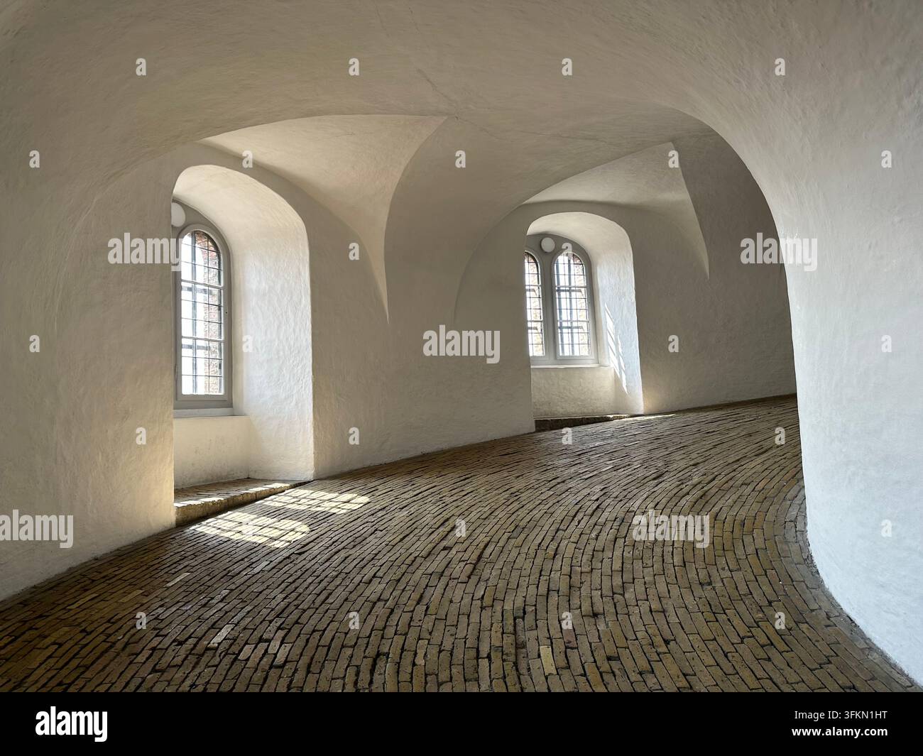 Rampa a spirale all'interno della Rundetaarn con pavimento in mattoni curvo, pareti bianche e finestre ad arco, Copenaghen, Danimarca - Immagine stock catturata con smartphone