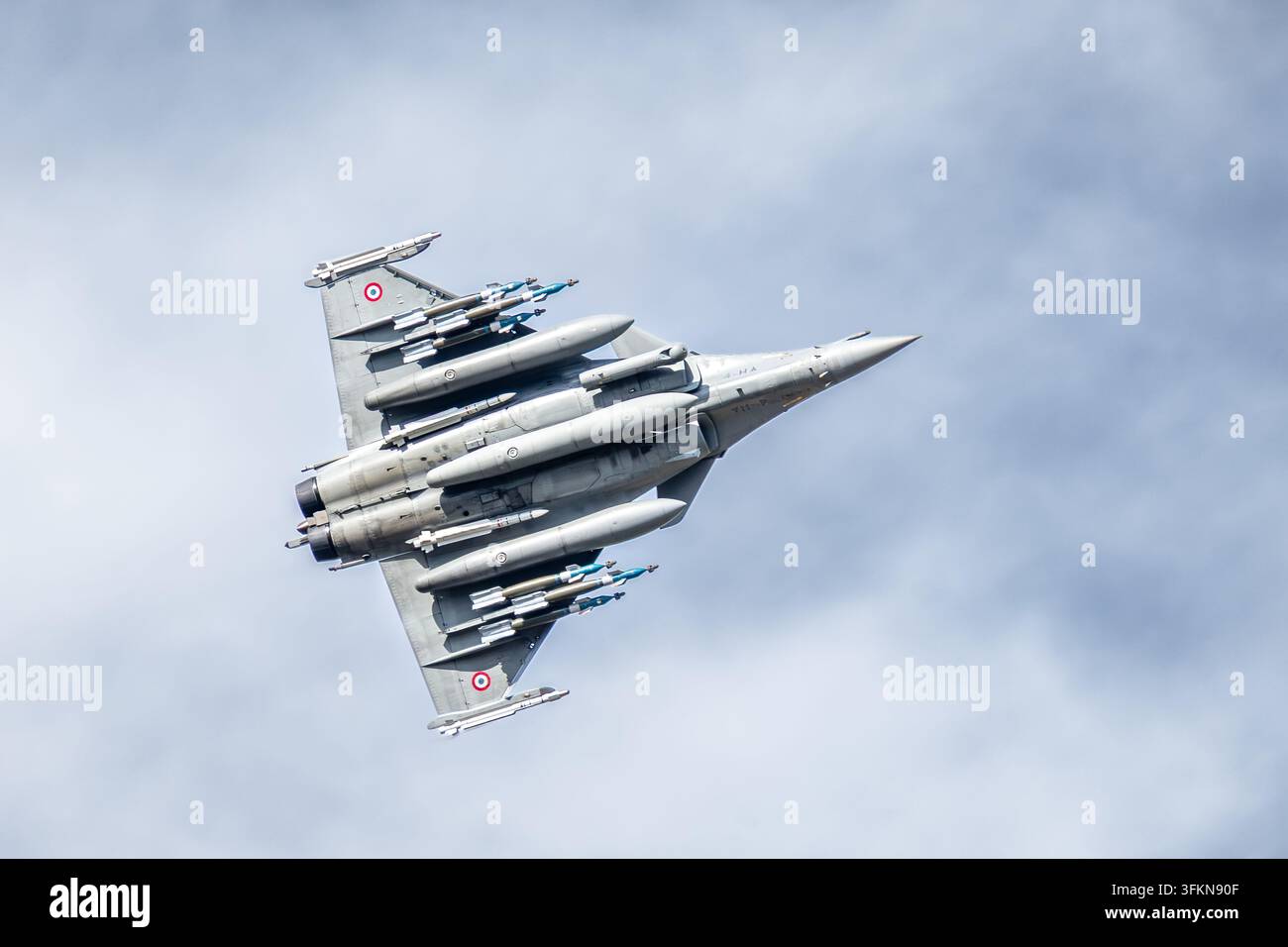 Vista dal basso di un caccia Dassault Rafale dell'Aeronautica Militare francese, armato di missili e bombe, in volo sopra la base aerea 113 di Saint-Dizier, Francia. Foto Stock