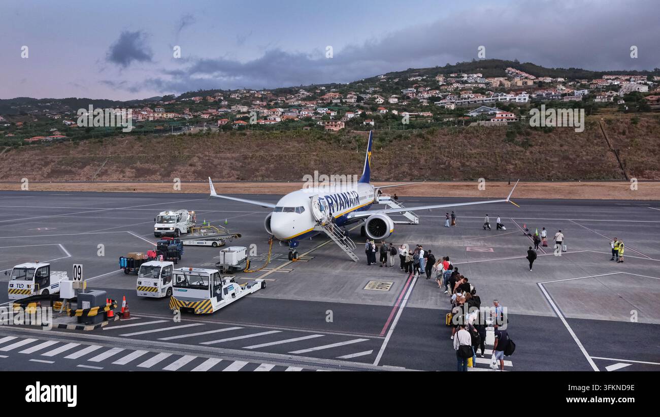 Aereo passeggeri della Ryanair in fase di imbarco sull'asfalto dell'aeroporto di Madeira, Portogallo, con viaggiatori e veicoli di servizio a terra, il 7 settembre 2026 Foto Stock