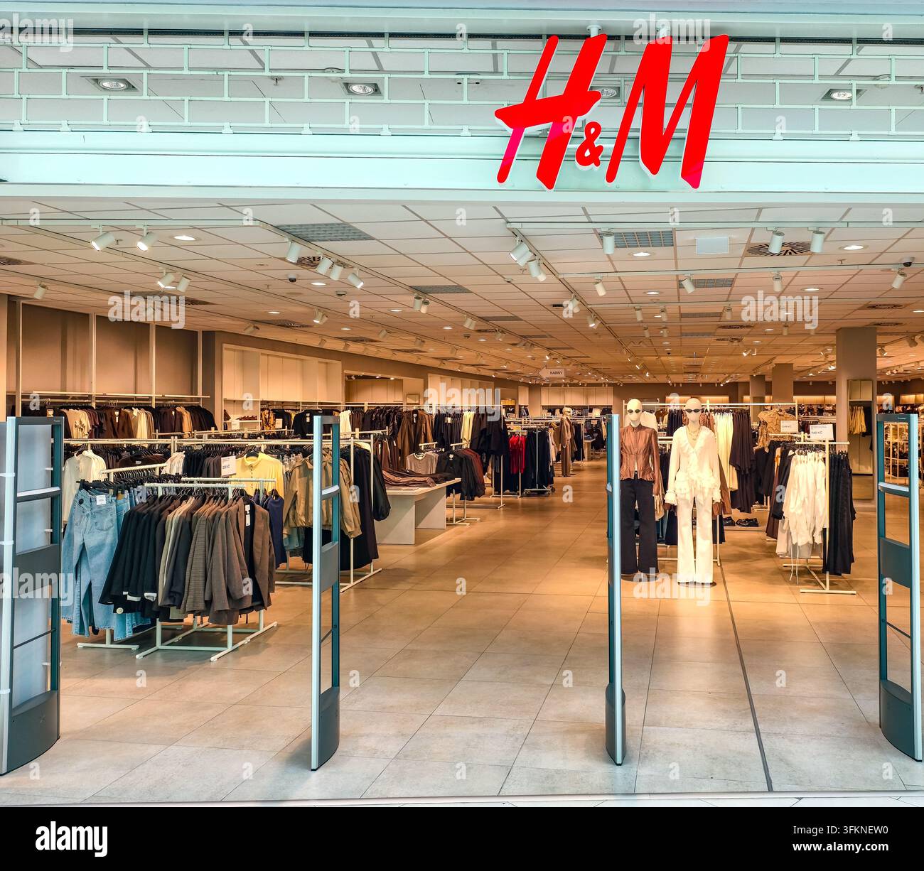 Praga, Repubblica Ceca – 25 settembre 2026: Ingresso del negozio di abbigliamento H e M con espositori di abiti e manichini in mostra Foto Stock