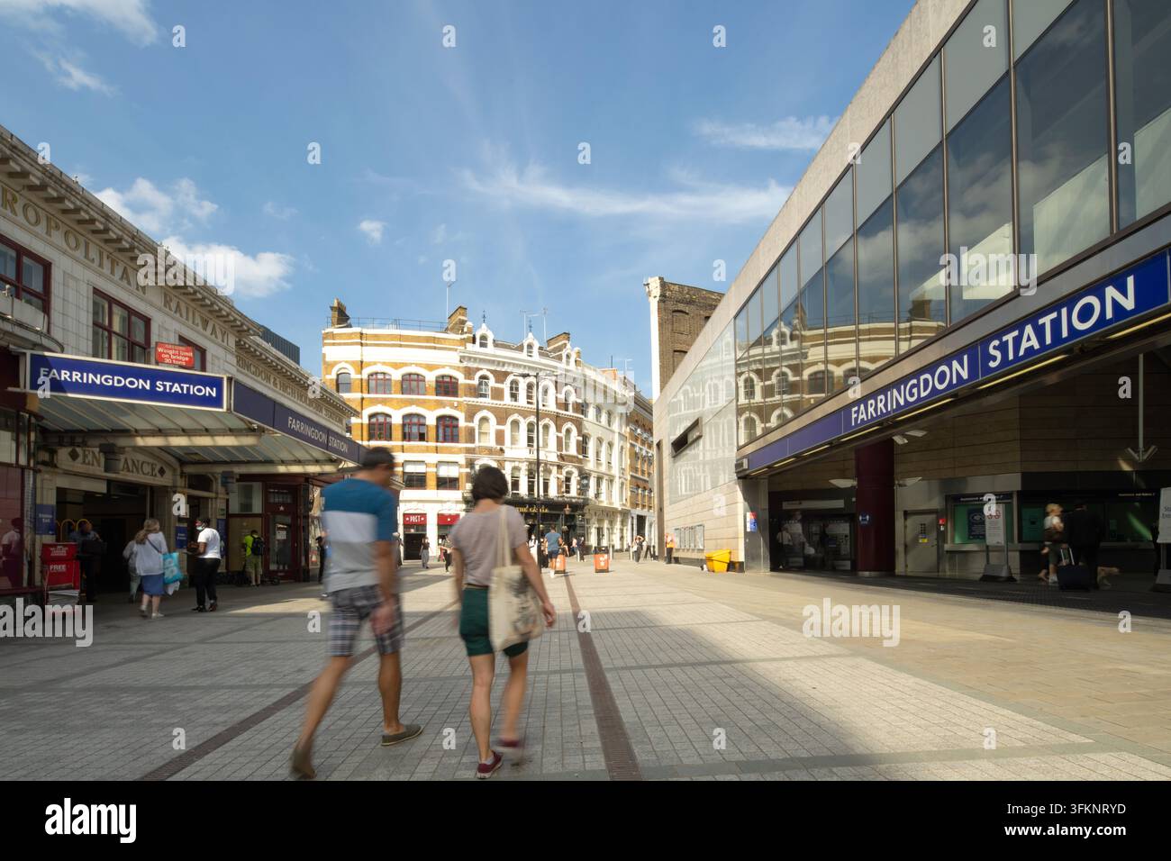 I pendolari passano davanti all'ingresso storico della Metropolitan Railway alla stazione di Farringdon, Londra, per prendere i loro treni. Foto Stock