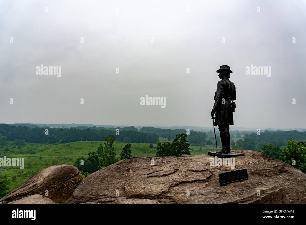 Viaggi e Storia: Statua in bronzo del Governatore Generale K. Warren che domina Devil's Den dal vertice di Little Round Top a Gettysburg Foto Stock