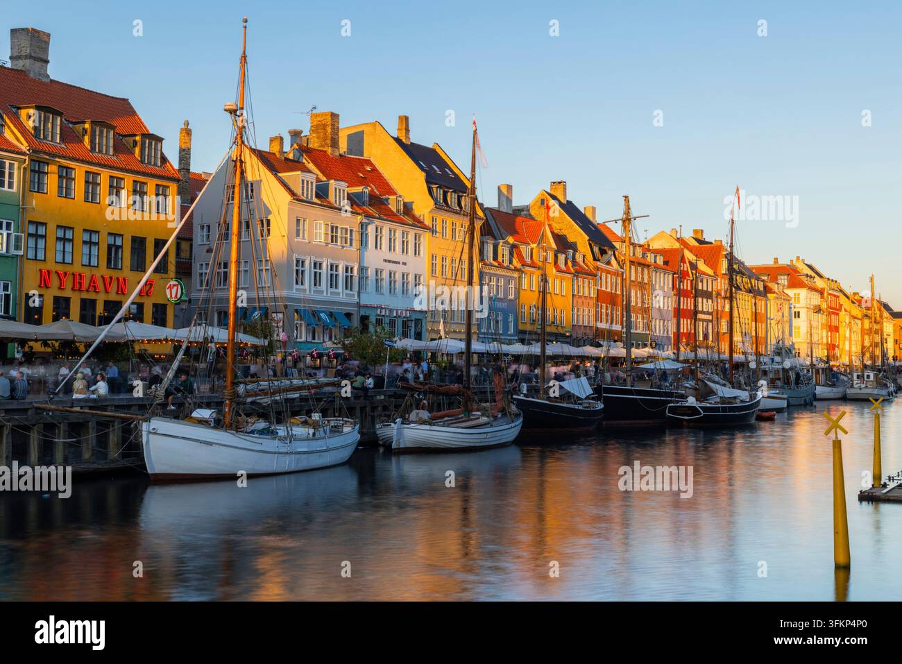 Barche davanti a case dai tetti colorati a Nyhavn, Copenaghen, Danimarca Foto Stock