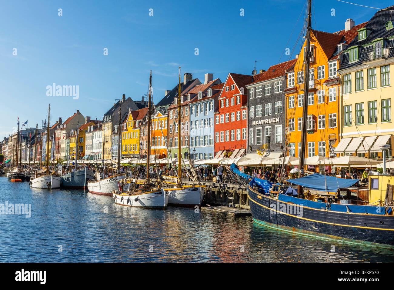 Barche davanti a case dai tetti colorati a Nyhavn, Copenaghen, Danimarca Foto Stock