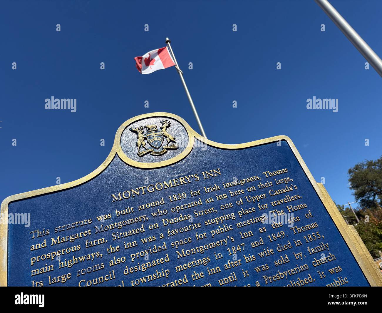 Targa storica di Montgomery's Inn a Toronto, Canada, con testo descrittivo sugli immigrati irlandesi Thomas e Margaret Montgomery sotto un cielo sereno. Foto Stock