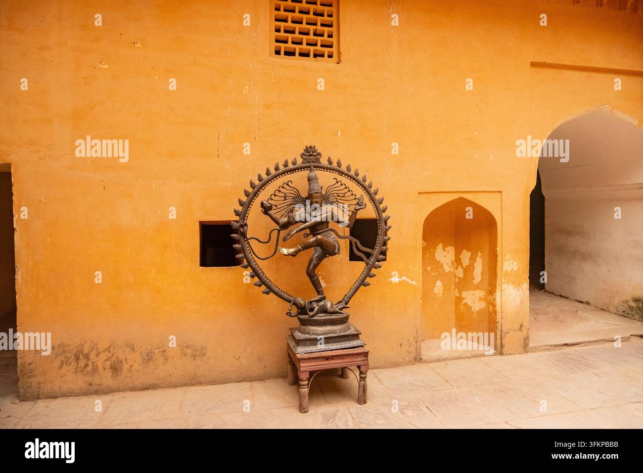 Statua di bronzo di Nataraja (il dio indù Shiva come danzatore cosmico) posizionata su un muro giallo rustico all'interno del Forte Amber, Jaipur, India. Foto Stock