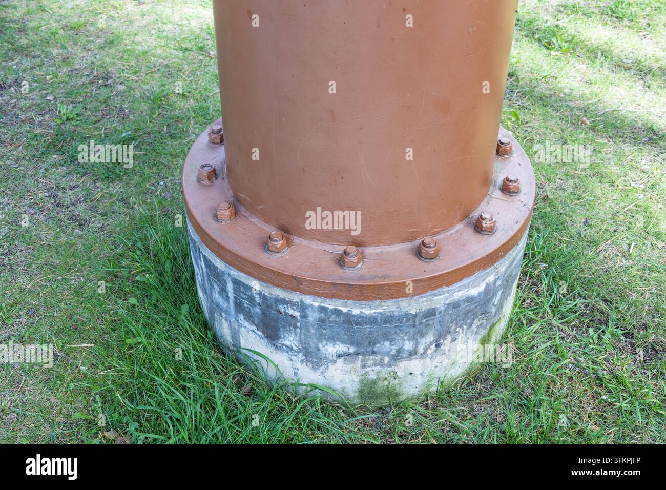 Base a flangia imbullonata di un palo in acciaio su fondazione in cemento Foto Stock