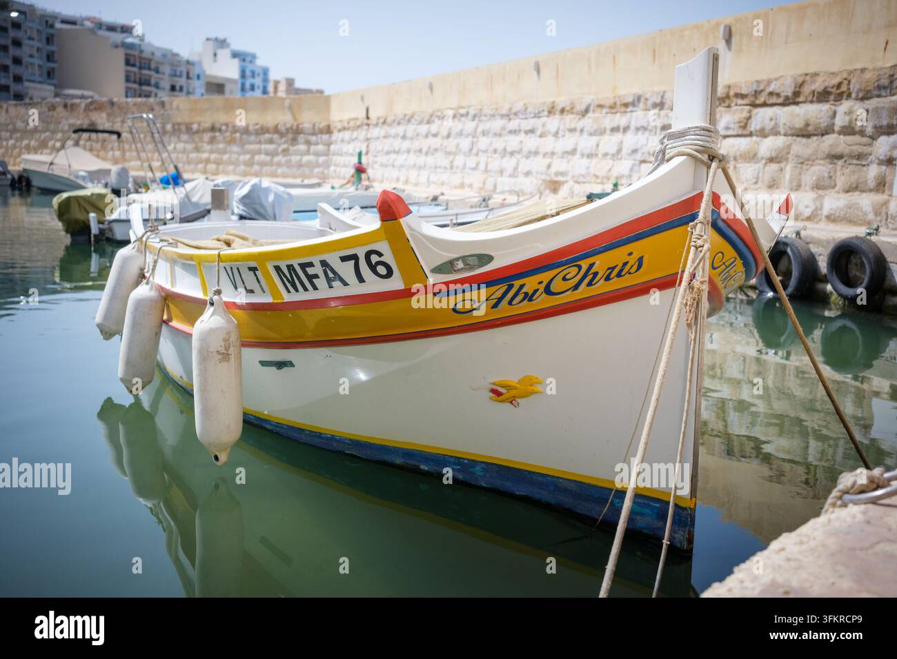 Tradizionali barche da pesca maltesi in legno colorate ormeggiate in un piccolo porto vicino a St Pauls Beach Bugibba, Malta Foto Stock