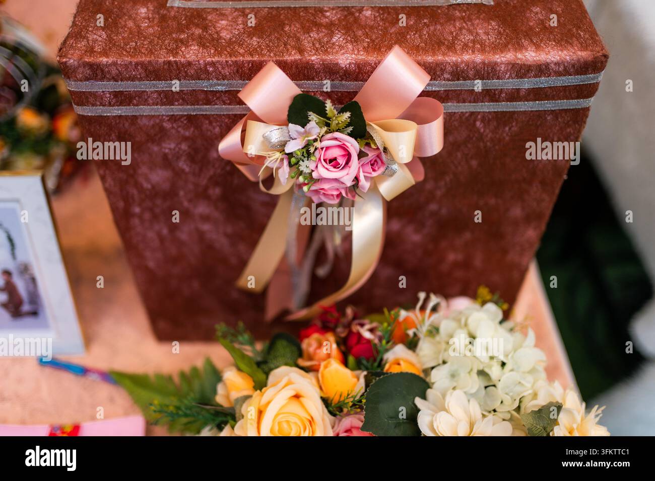 Elegante scatola per donazioni nuziali decorata con fiocco di nastro e fiori Foto Stock