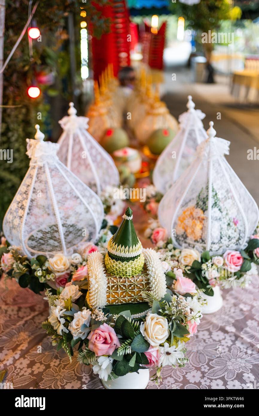 Allestimento tradizionale di una cerimonia nuziale thailandese con vassoi di fiori e copriletti di pizzo Foto Stock