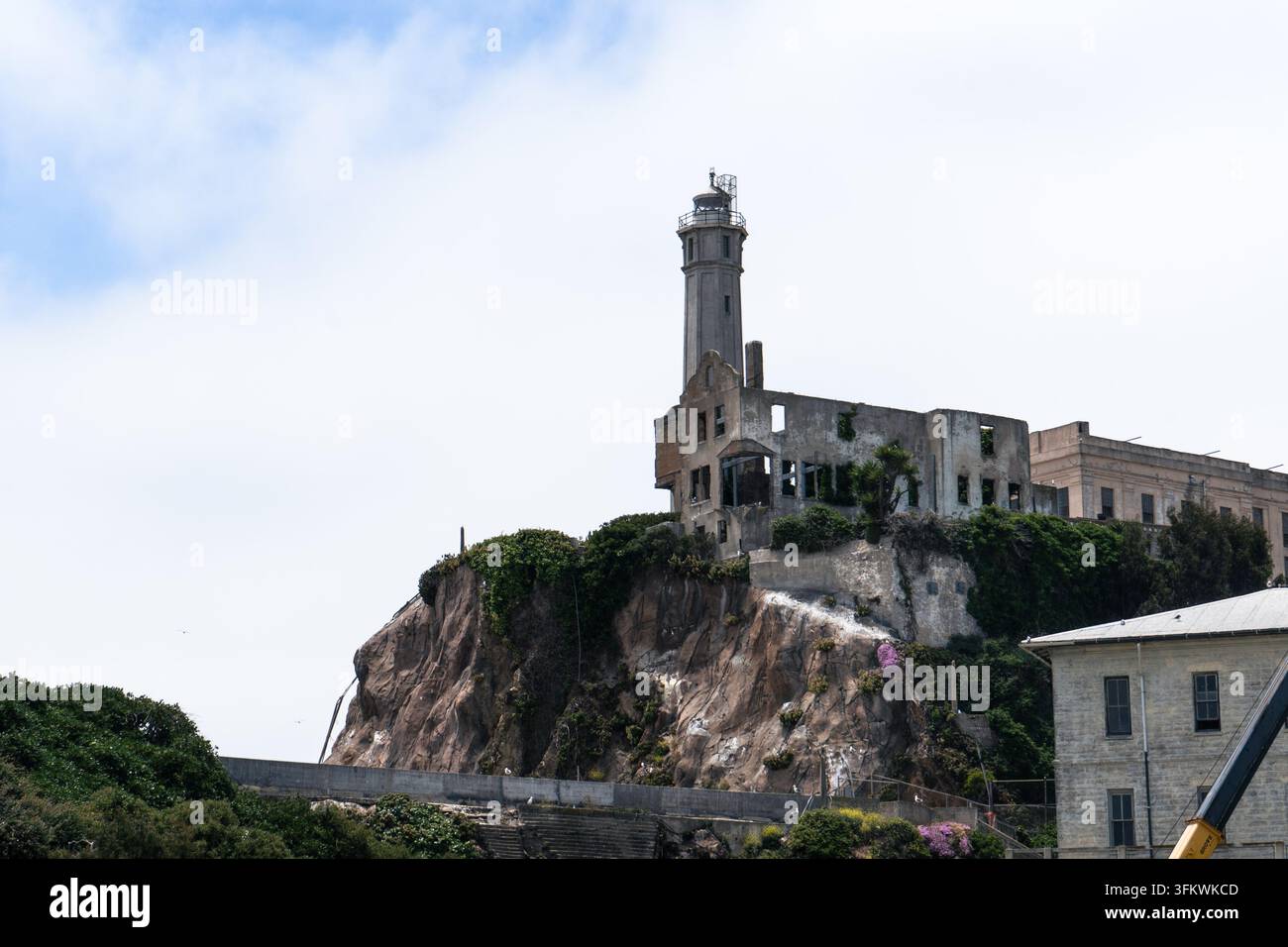 Faro di Alcatraz sopra le rovine. Il faro si erge sopra edifici abbandonati sulla scogliera. Foto Stock