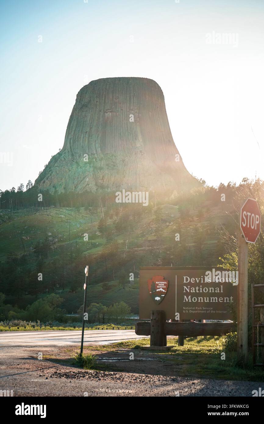 DEVILS TOWER, WYOMING - 28 MAGGIO 2022: Il cartello d'ingresso del Monumento Nazionale di Devils Tower con la torre sullo sfondo. Foto Stock