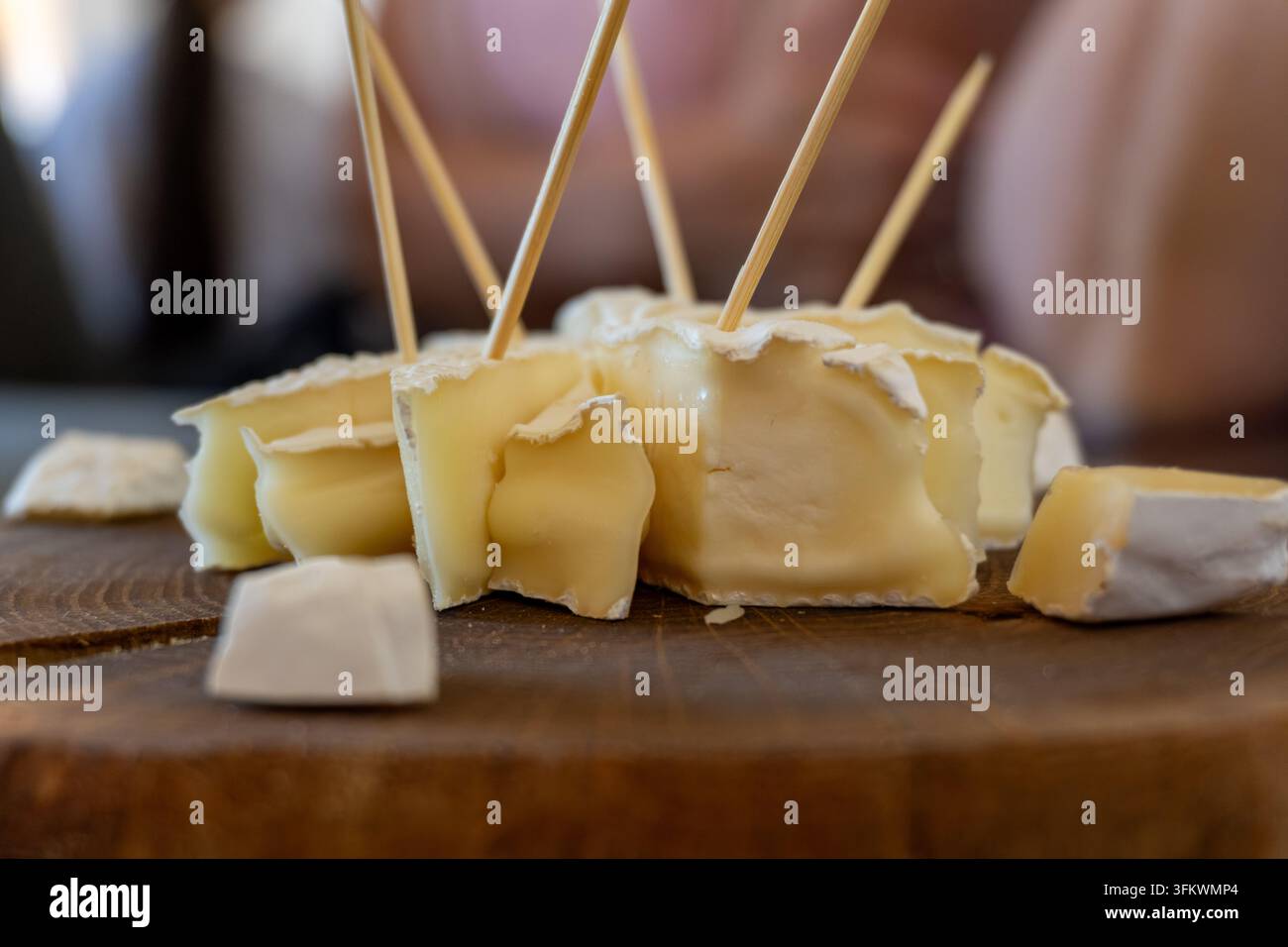 Fette di formaggio Camembert con stuzzicadenti su una tavola di legno rustica Foto Stock
