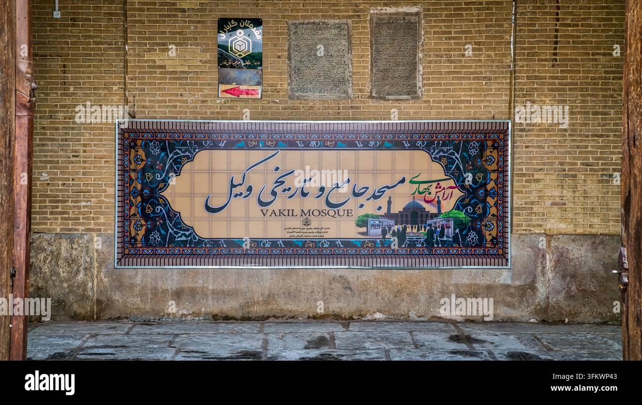 Shiraz, Iran - 4 maggio 2019: cartello della moschea Vakil in persiano e inglese, targa d’ingresso in piastrelle della moschea del XVIII secolo di Karim Khan Zand, il cui titolo Vakil significa reggente Foto Stock