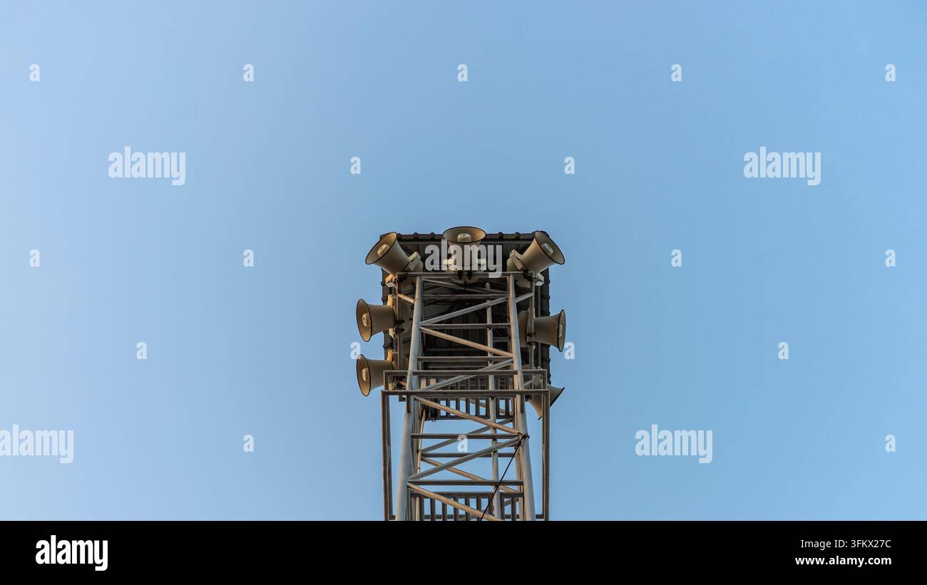 Torre di sonorizzazione pubblica e concetto di altoparlante a corno di trasmissione, torre di telecomunicazione in acciaio con altoparlanti contro il cielo blu, rappresentante civile Foto Stock