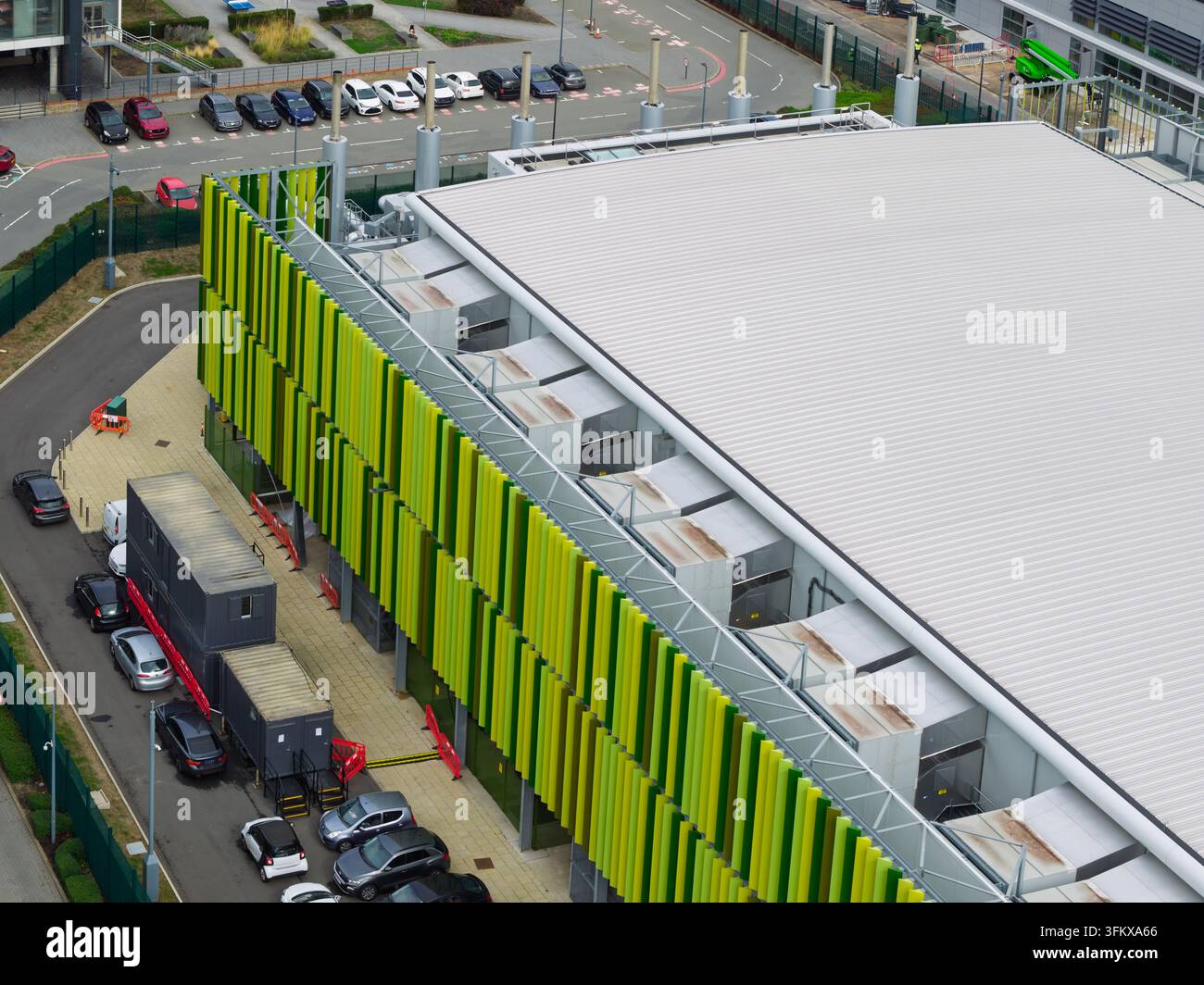 Vista aerea di un moderno edificio di data center con persiane verticali verdi e gialle, un grande tetto piatto e un parcheggio con auto negli Stati Uniti Foto Stock