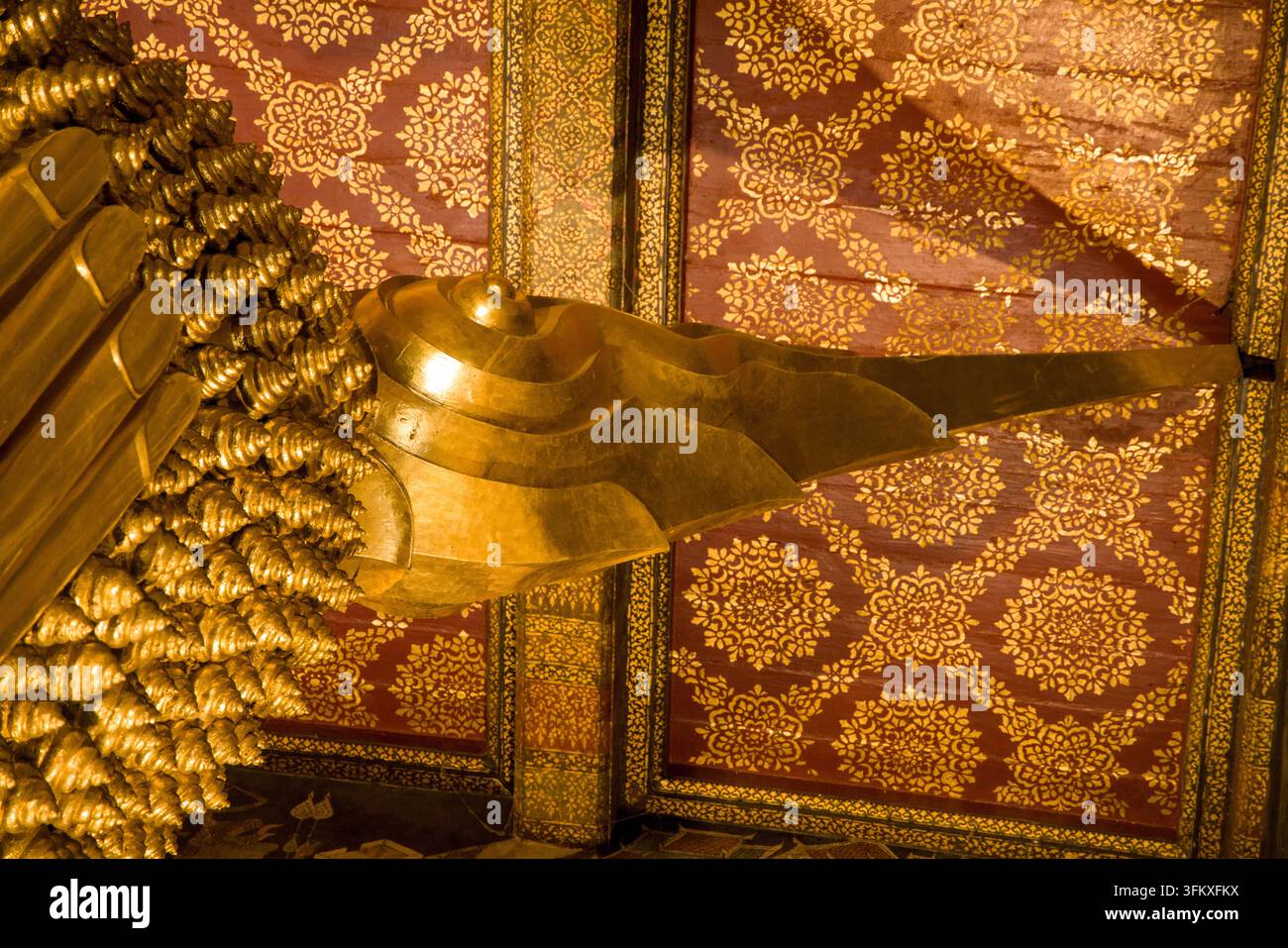 Una dettagliata ripresa di profilo della punta fiammeggiante iconica – il simbolo dell'illuminazione – sulla statua del Buddha sdraiato al Wat Pho di Bangkok. Foto Stock