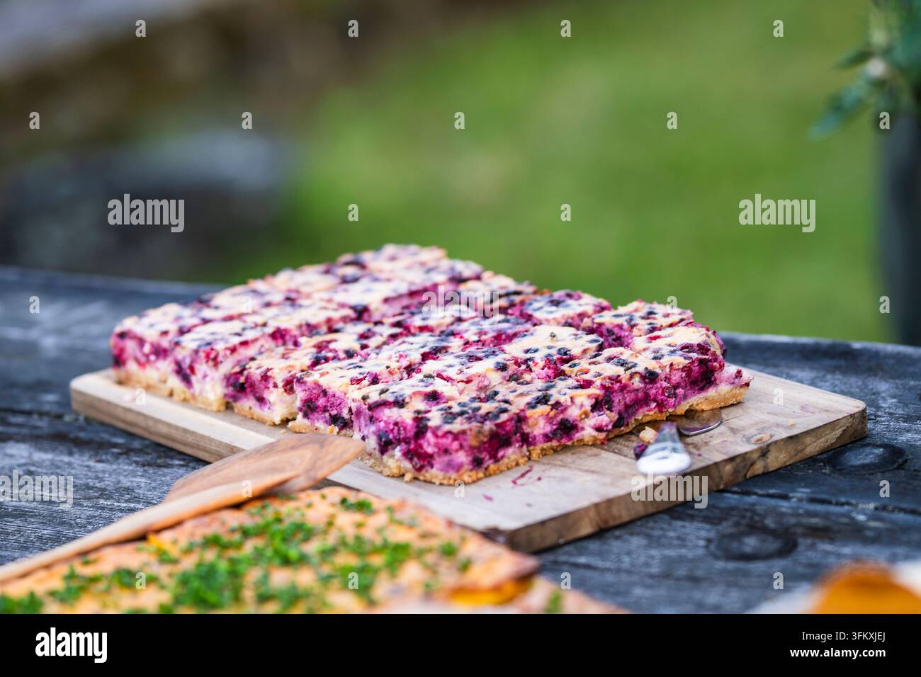 Torta crumble fatta in casa ai mirtilli e frutti di bosco tagliata a quadretti, con una base dorata e burrosa e uno strato generoso di succose bacche scure. Foto Stock