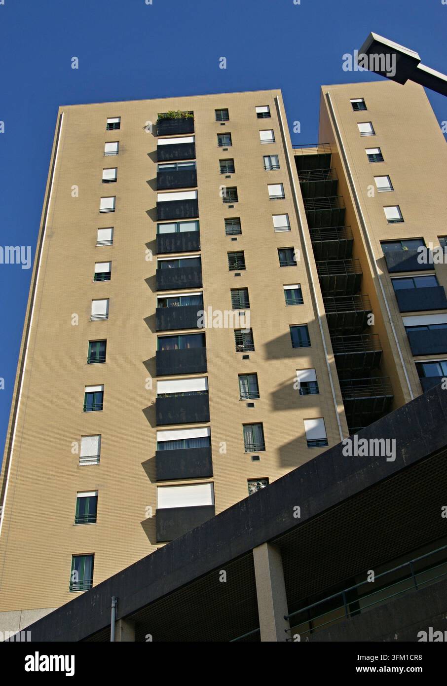 Facciata di un edificio residenziale con molte finestre, balconi e un cielo blu terso Foto Stock