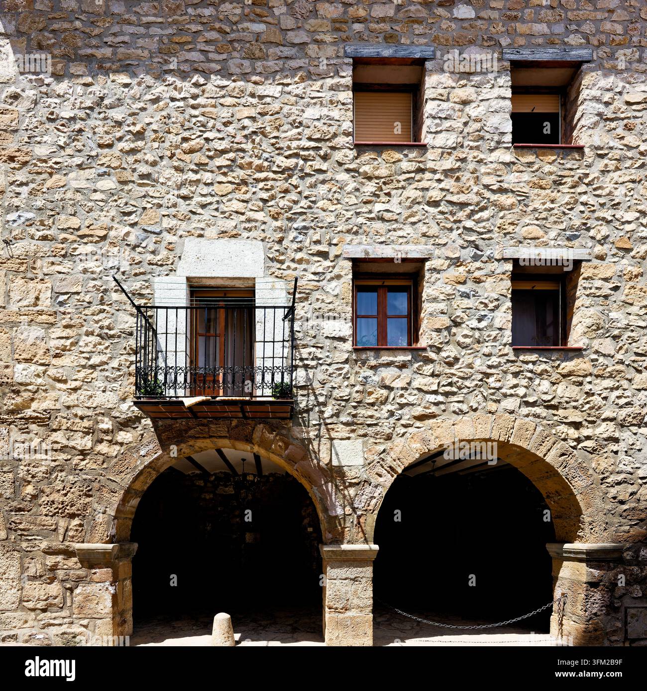 Un antico edificio in pietra con diverse finestre e un piccolo balcone, atmosfera rustica, Maestrazgo (Maestrat, Alto Maestrazgo, l'Alt Maestrat), Mos in Spagna Foto Stock