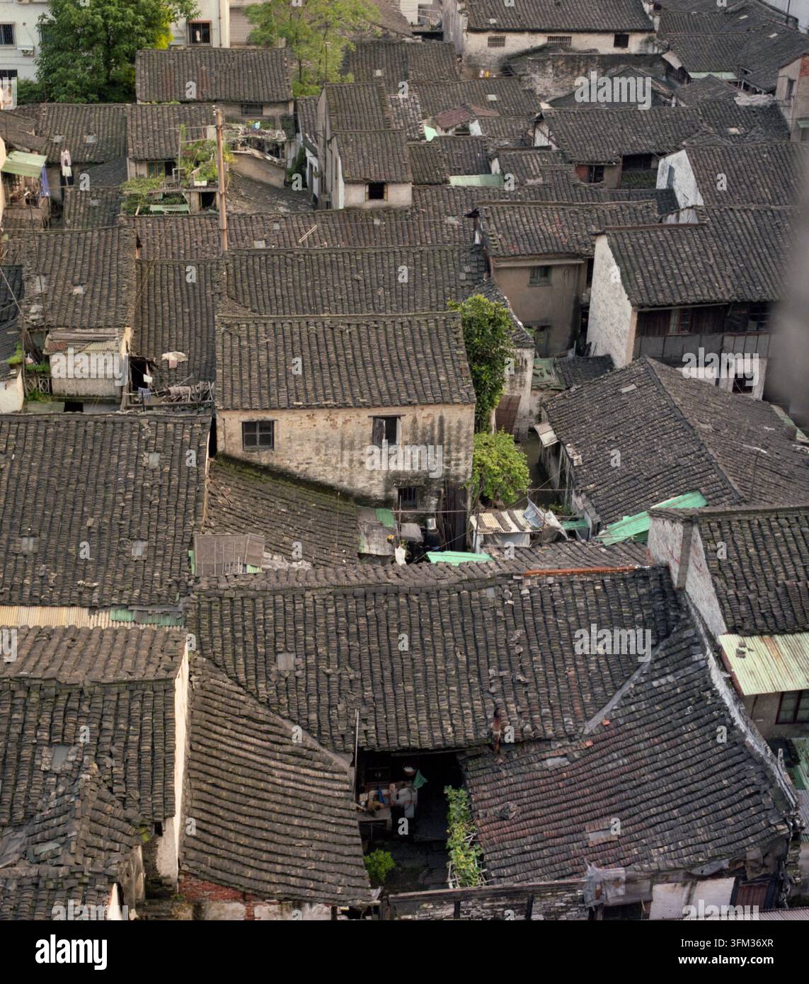 I locali vivono sotto tetti di tegole grigie in una città sull'acqua del Jiangnan degli anni '90 in Cina, preservando l'architettura vernacolare tradizionale. Foto Stock