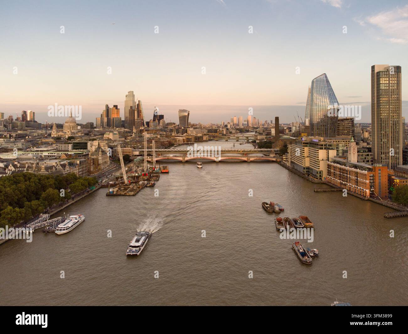 Pendolari e turisti scivolano lungo il Tamigi oltre il Ponte Blackfriars, viaggiando attraverso Londra passando davanti alla sua iconica skyline al tramonto. Foto Stock