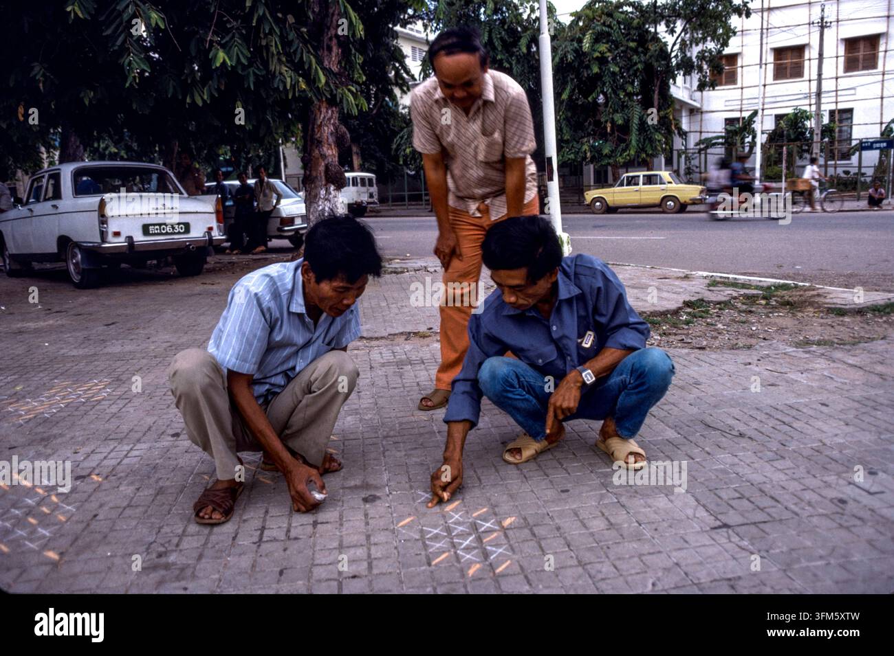 Persone che giocano a un gioco sui ciottoli, Phnom Penh, Cambogia, settembre 1988 Foto Stock
