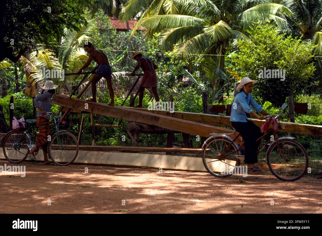 Due falegnami al lavoro che tagliano assi da tronchi d'albero, provincia di Prey Veng, Cambogia, settembre 1988. Foto Stock