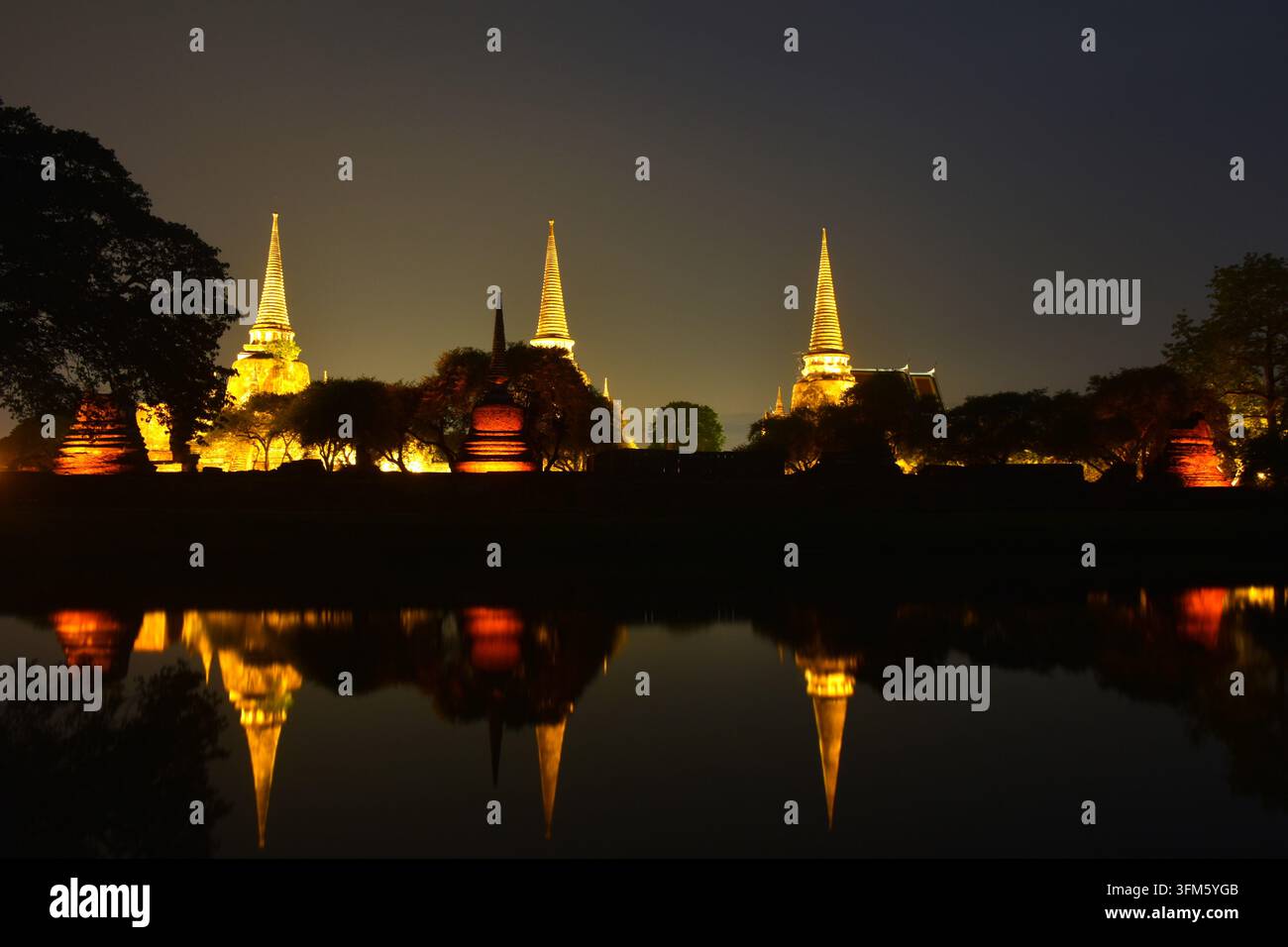 Pagoda di Wat Phra Si Sanphet o tempio del santo, splendido Onnisciente riflesso sull'acqua con lampada elettrica nella notte Foto Stock
