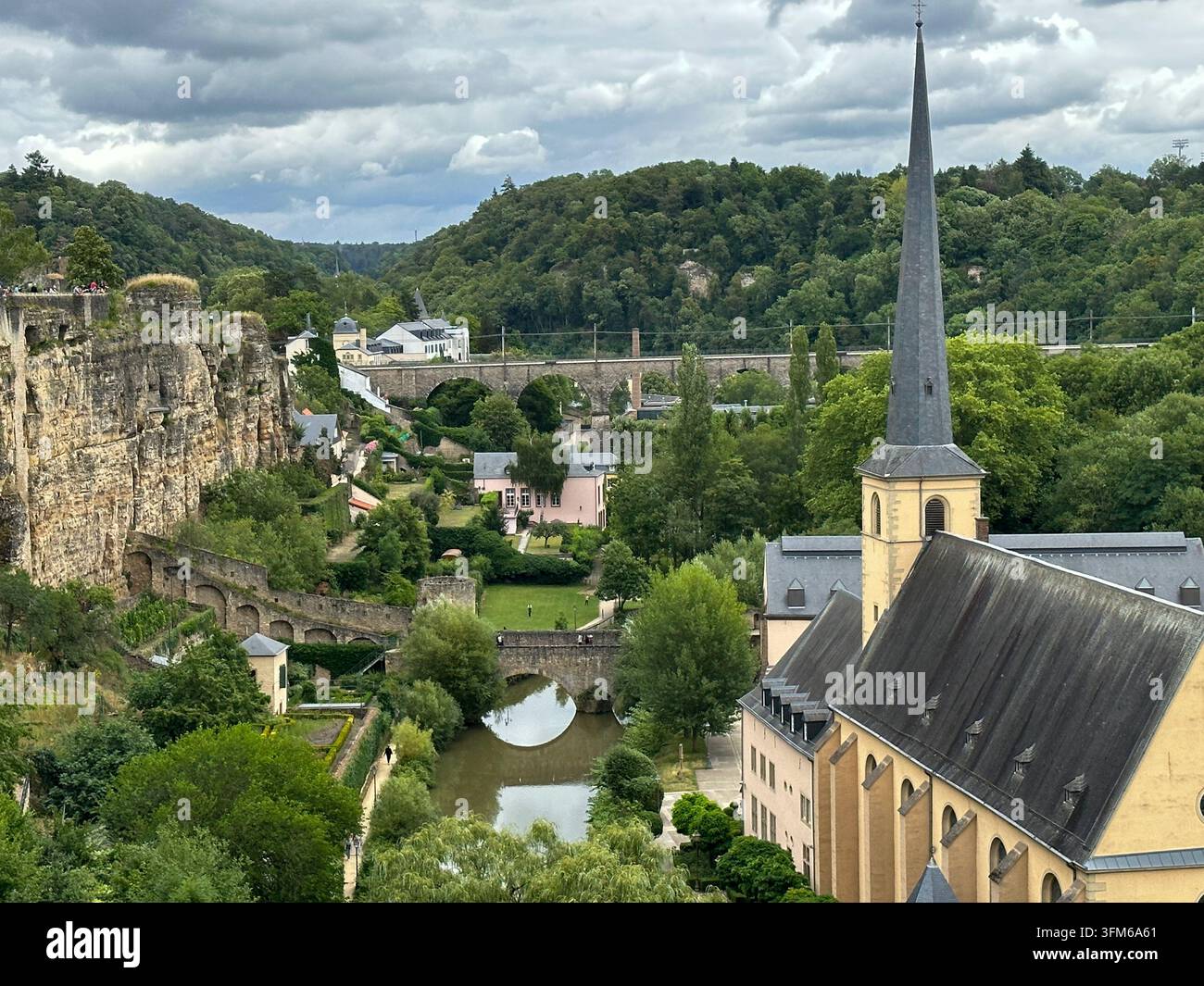 Panorama scenico di una città europea con chiesa storica e ponte di pietra. Vista ad angolo alto di una città storica europea con un alto campanile, pietra Foto Stock
