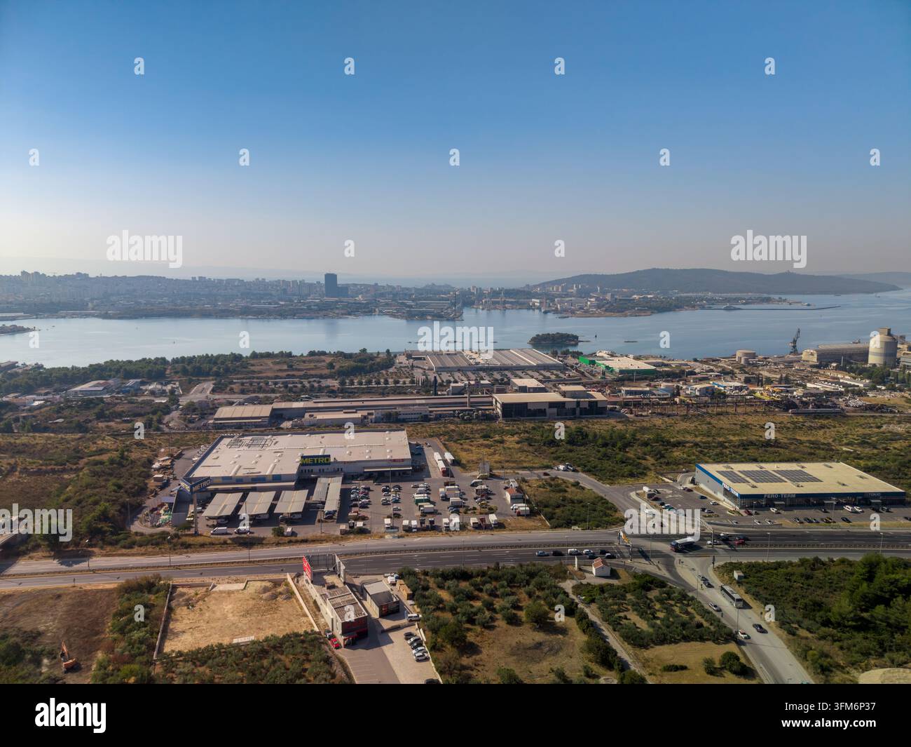 SPLIT, CROAZIA - 9 SETTEMBRE 2026 Il lungomare industriale e l’estensione urbana si estendono su una vasta baia, con CEMEX come contesto fornito. Magazzini, silos, strade a Foto Stock