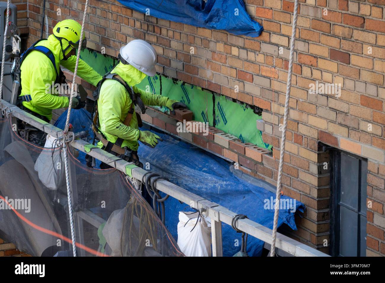 Operai edili in un edificio di appartamenti a New York in un cesto sospeso, Midtown Manhattan, USA 2026 Foto Stock