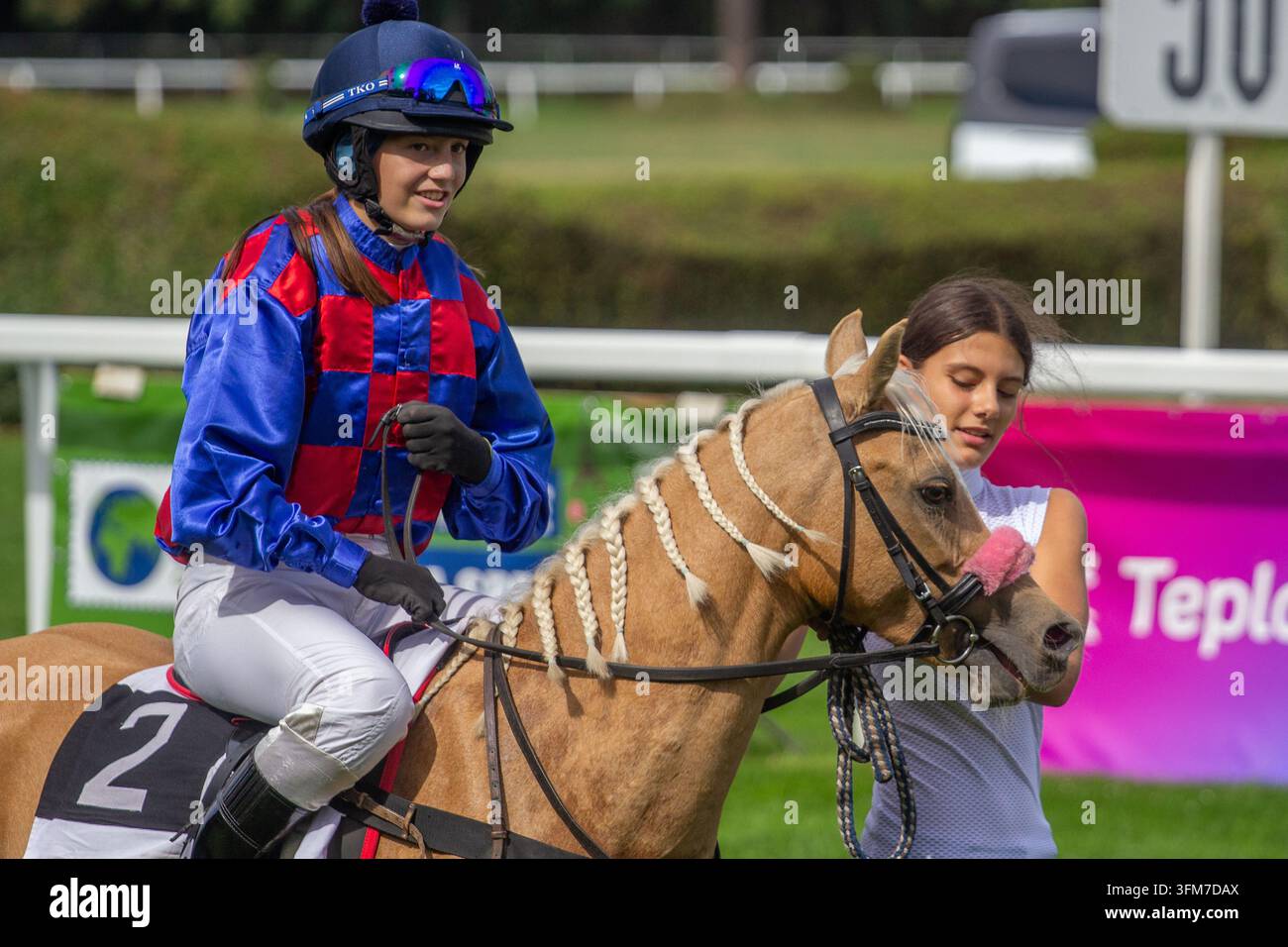 Persone e pony a una corsa di cavalli in un'ippodromo Foto Stock