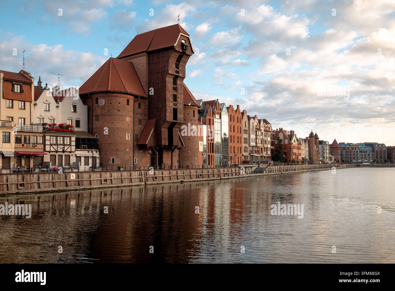 La Gru medievale di Danzica e gli edifici storici del lungomare si trovano accanto al fiume Motlawa all'alba. Foto Stock