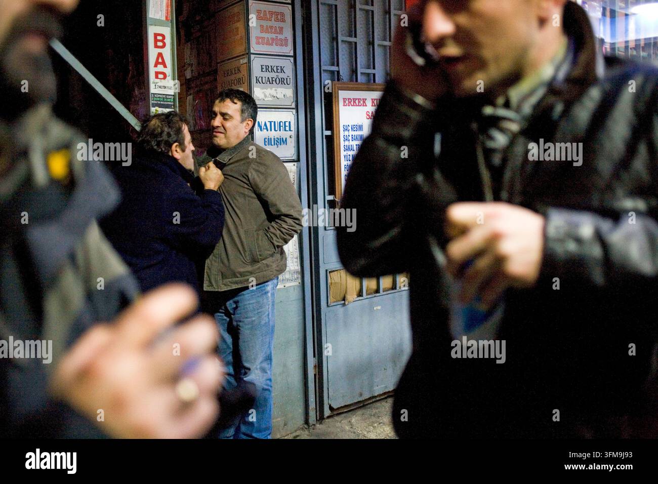 Un momento di tensione su una strada a Beyoglu, Istanbul, mentre un uomo arrabbiato afferra un altro per il colletto e i pedoni passano in primo piano. Foto Stock
