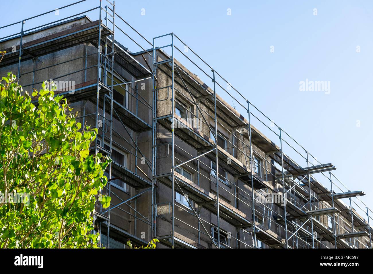 Edificio residenziale in corso di isolamento termico e riparazione esterna con ponteggio. Foto Stock